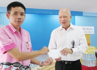 Dr. Sunya Viravaidya (right), CEO of Pattaya International Hospital makes a donation of rice, food and household articles to a representative of the Baan Banglamung Social Welfare Development Center for the care of the elderly residents.